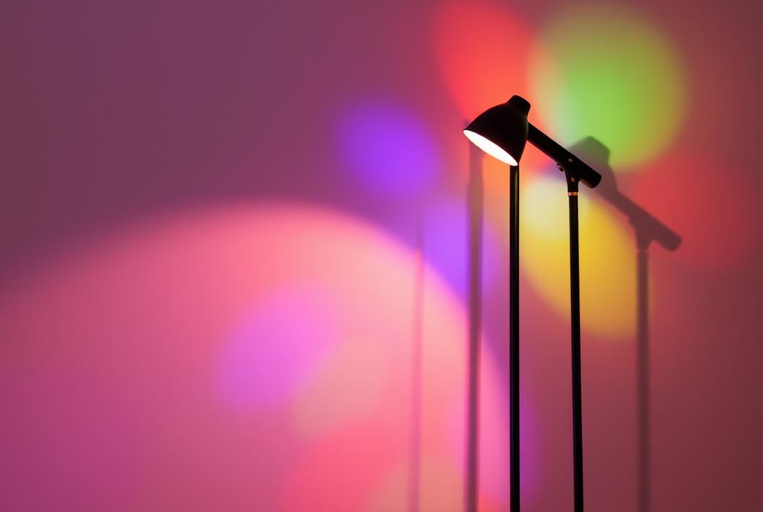  - A tall lamp with adjustable brightness and color settings, casting colorful shadows on the wall. ;